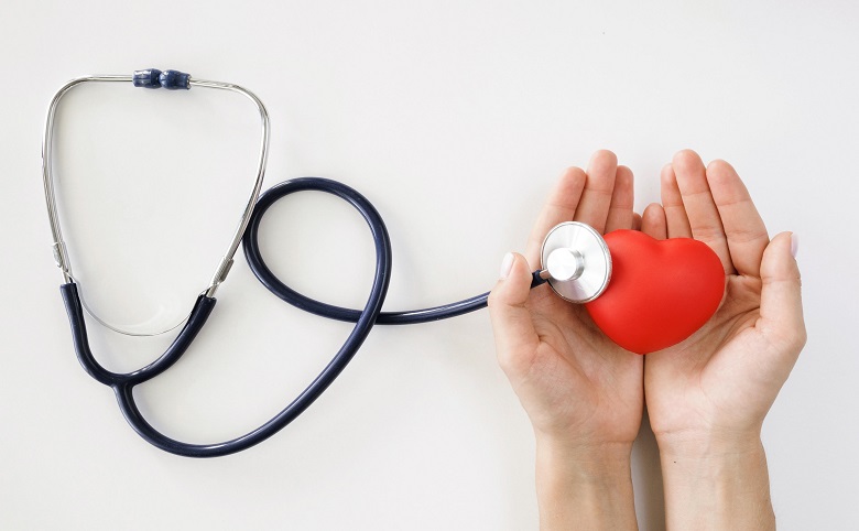 flat-lay-hands-holding-heart-shape-with-stethoscope